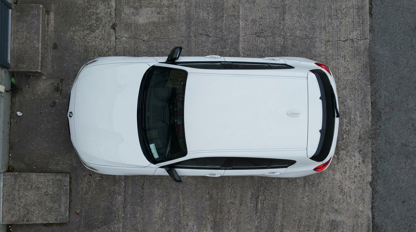 Top-down view of a white BMW 1 Series roof and tinted panoramic sunroof glass