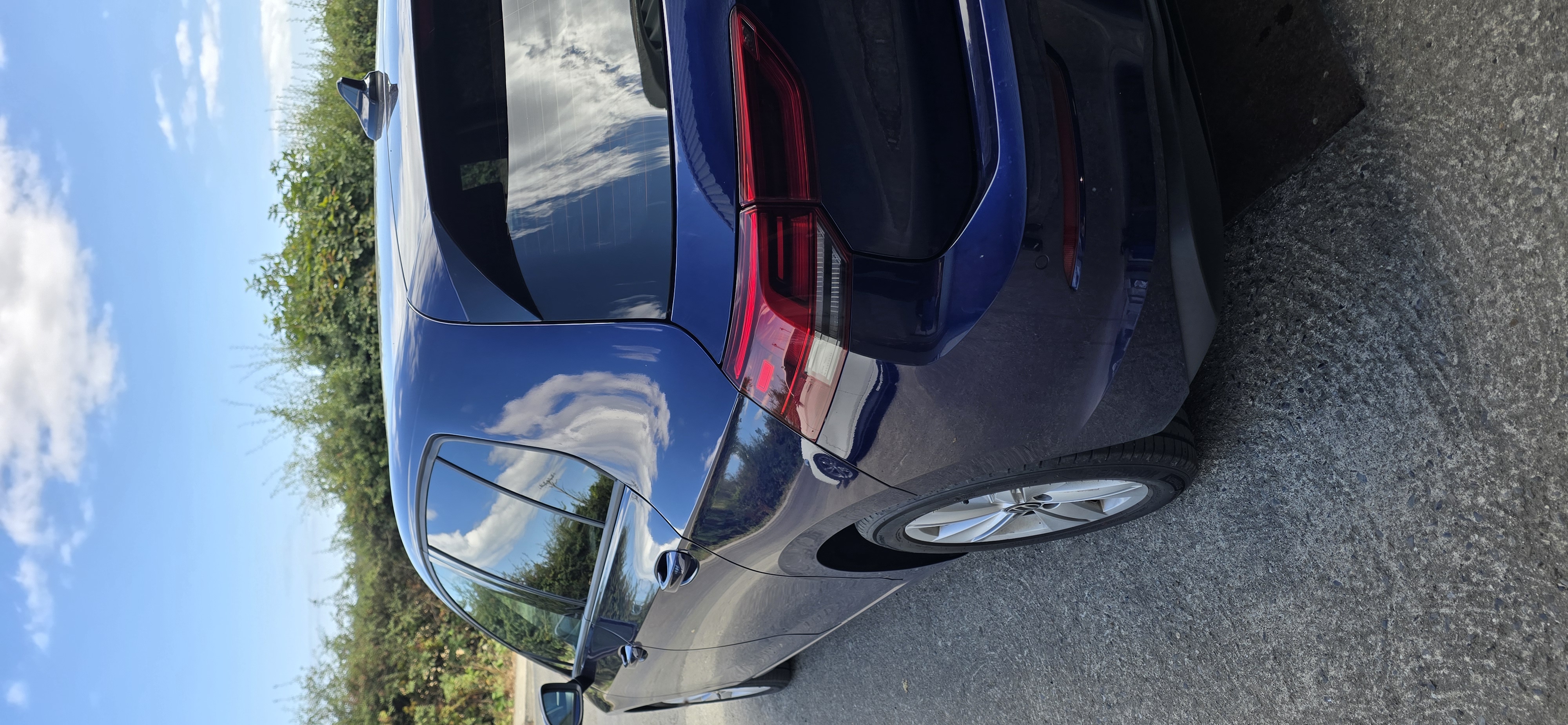 Rear three-quarter view of a blue Volkswagen Golf hatchback with freshly tinted glass