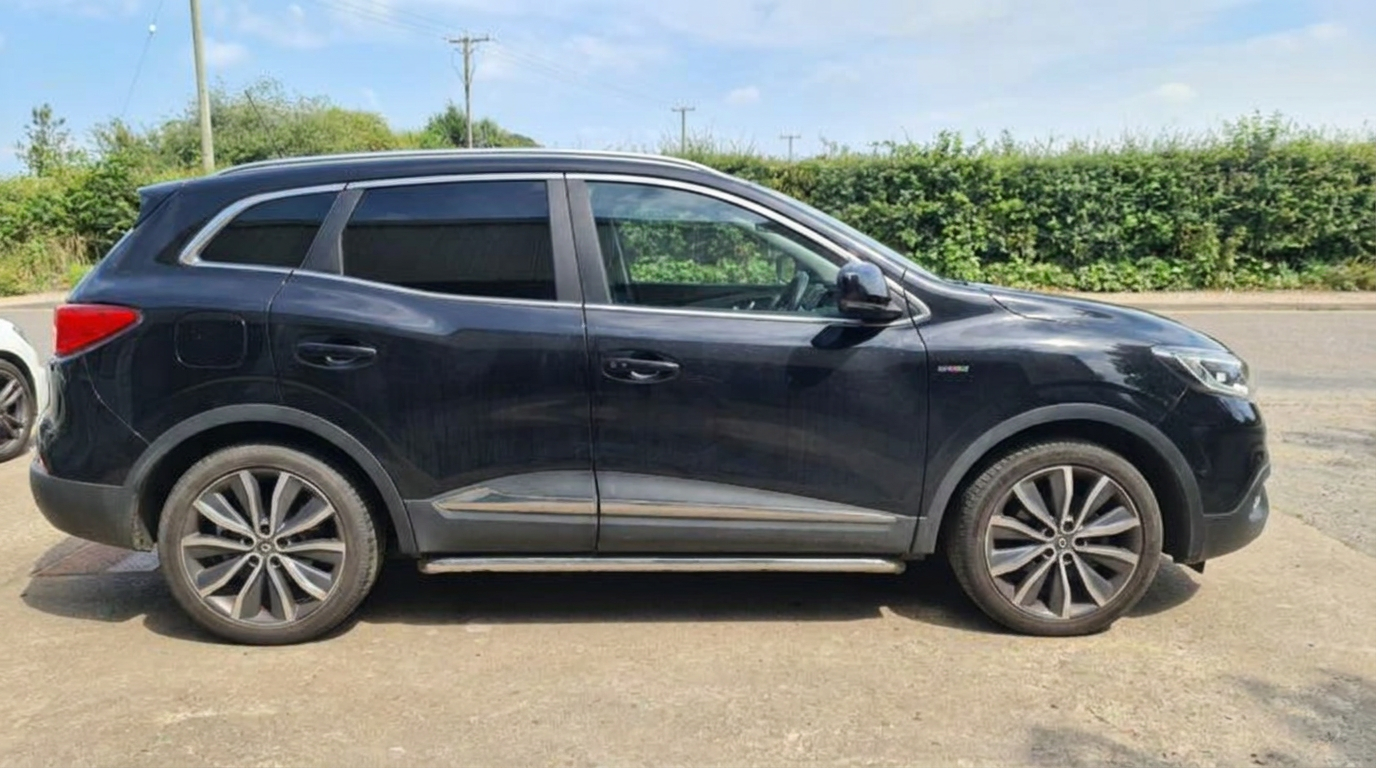 Side profile of a black Renault Kadjar showing the dark tinted rear door and quarter glass
